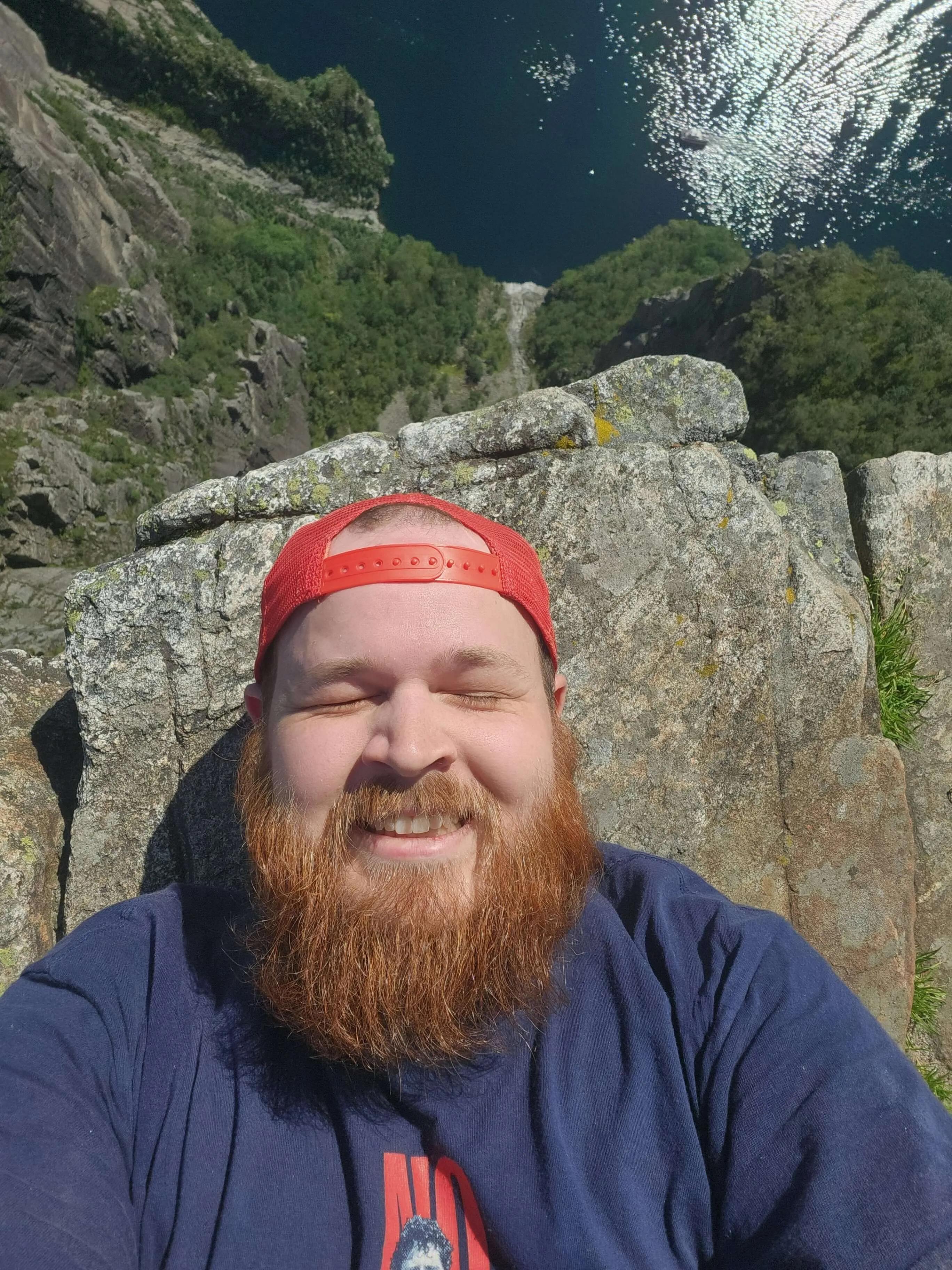 A selfie from the cliff on Preikestolen, with me laying down and taking a photo of me at the end of the cliff thinking don't drop it don't drop it don't drop it