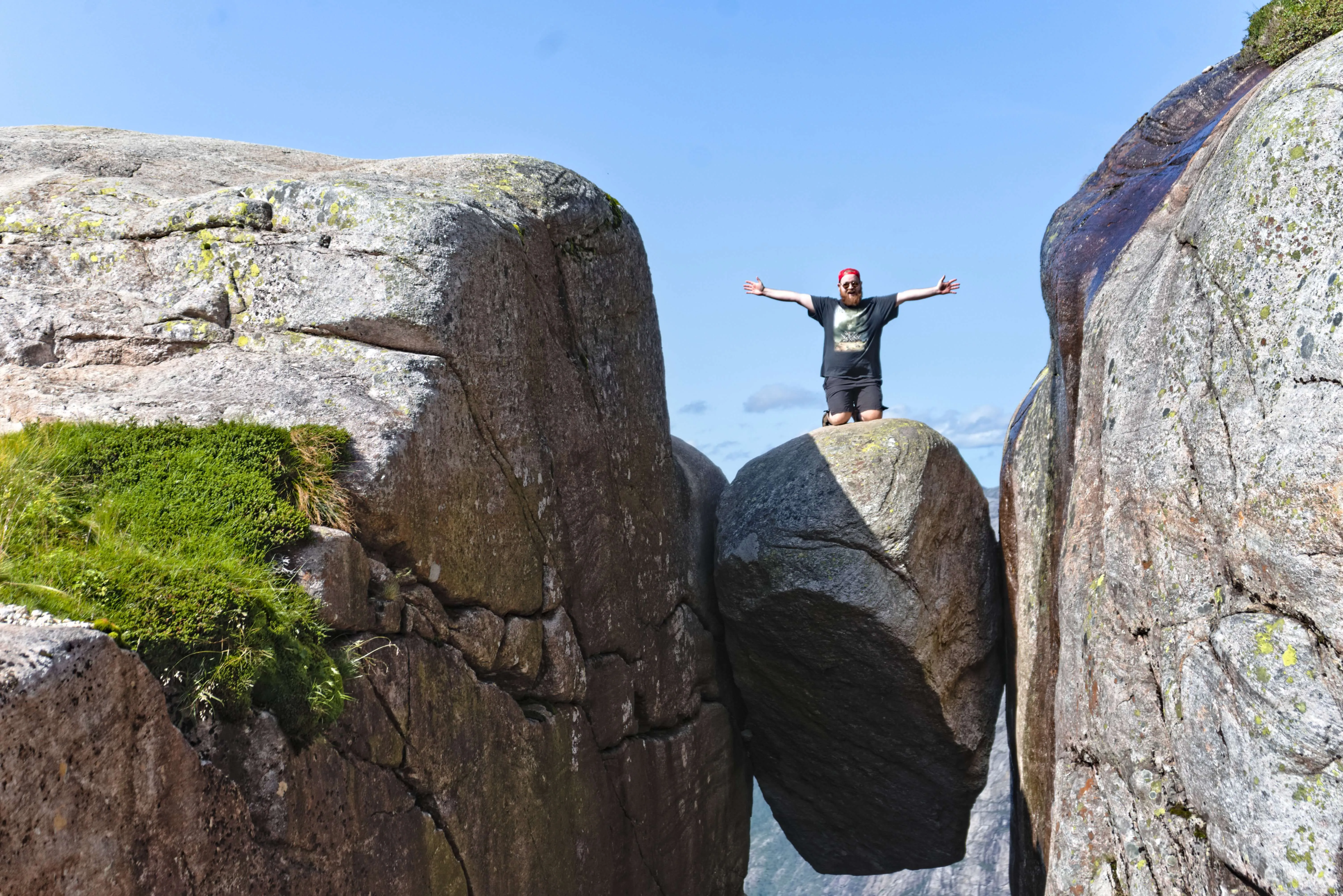 A picture of me taken by a kind stranger at Kjeragbolten 2025, who even nudged me to leap out on to the round rock wedged inbetween the two rock faces, where I had to fight my fear of heights that was *quite* palpatable in the moment, I was shaking uncontrollable afterwards for a solid 15 min...